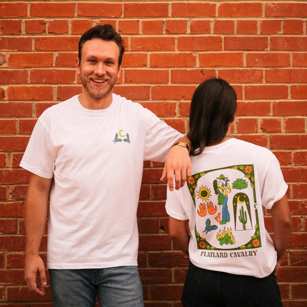 White t-shirt with colorful vegetable illustrations on the back.
