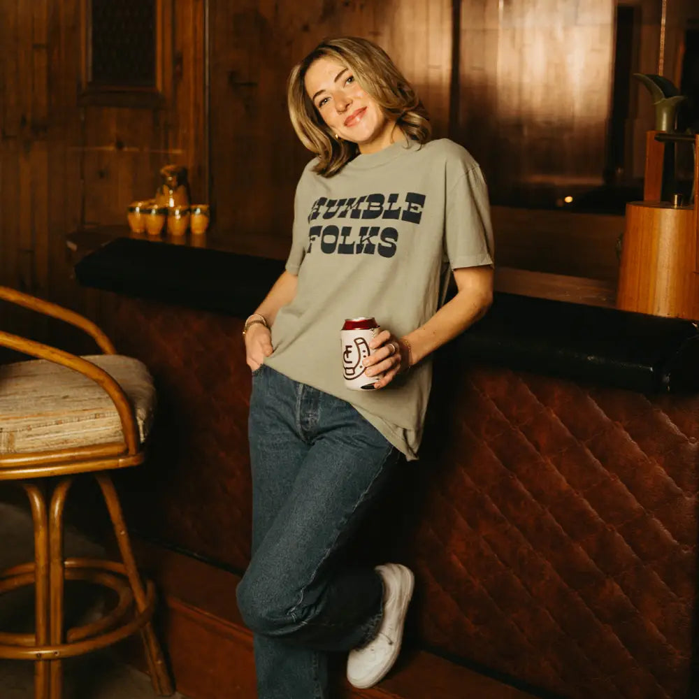 Woman in t-shirt and jeans holding a can.