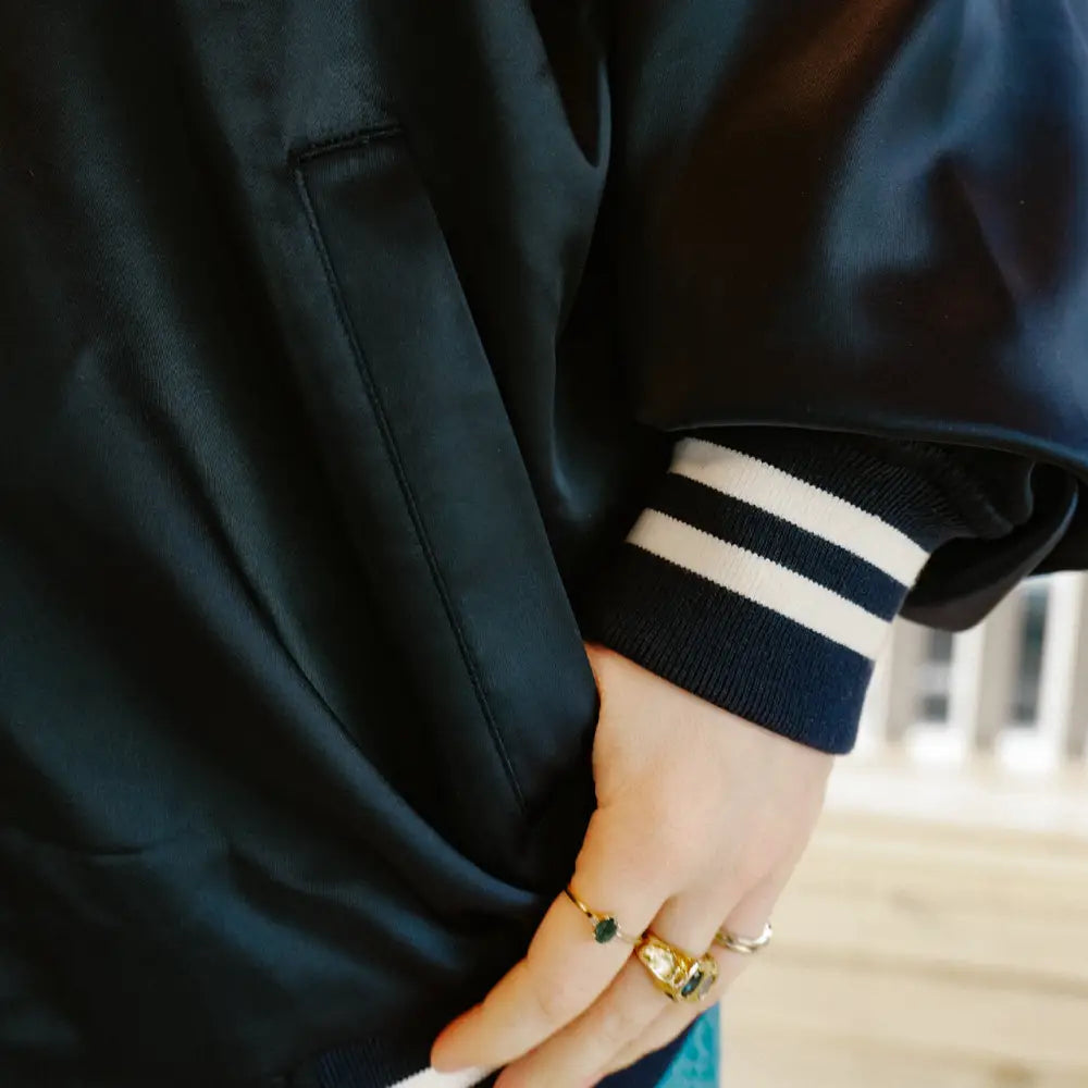 Navy bomber jacket with striped cuff.
