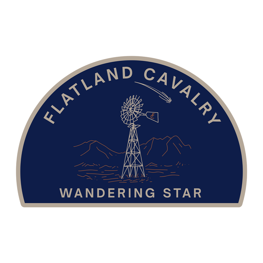 Semicircular logo patch featuring a windmill and mountains with text ’Flatland Cavalry Wandering Star’.