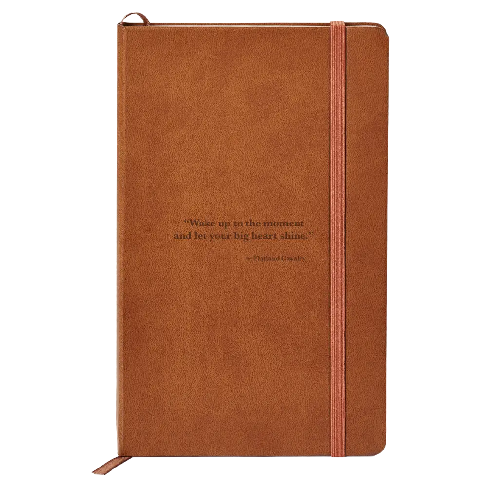 Brown leather-bound notebook with an elastic closure strap and an inspirational quote on the cover.