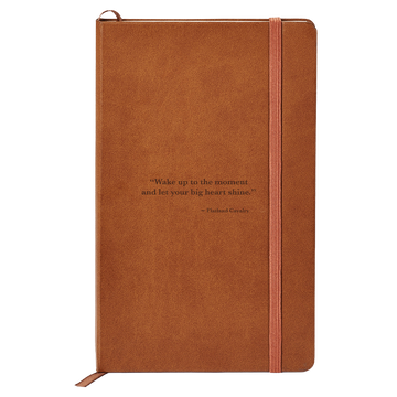 Brown leather-bound notebook with an elastic closure strap and an inspirational quote on the cover.